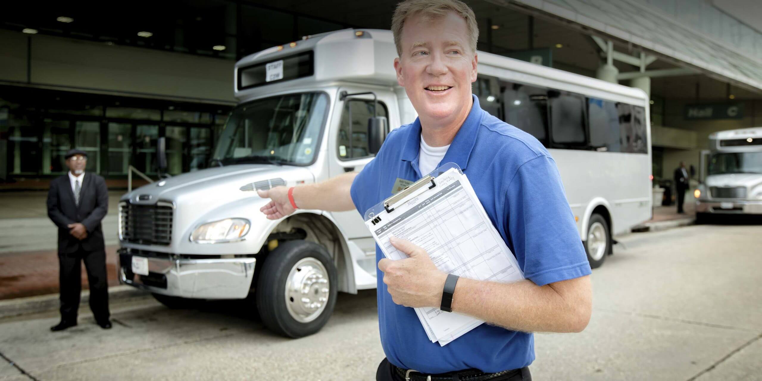 Man directing people to chartered vehicle