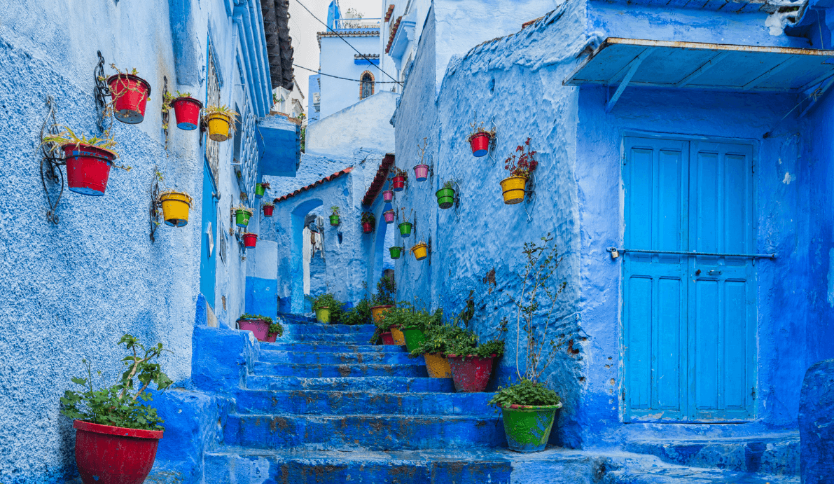 A Colorful alleyway with brightly painted pots on walls and steps