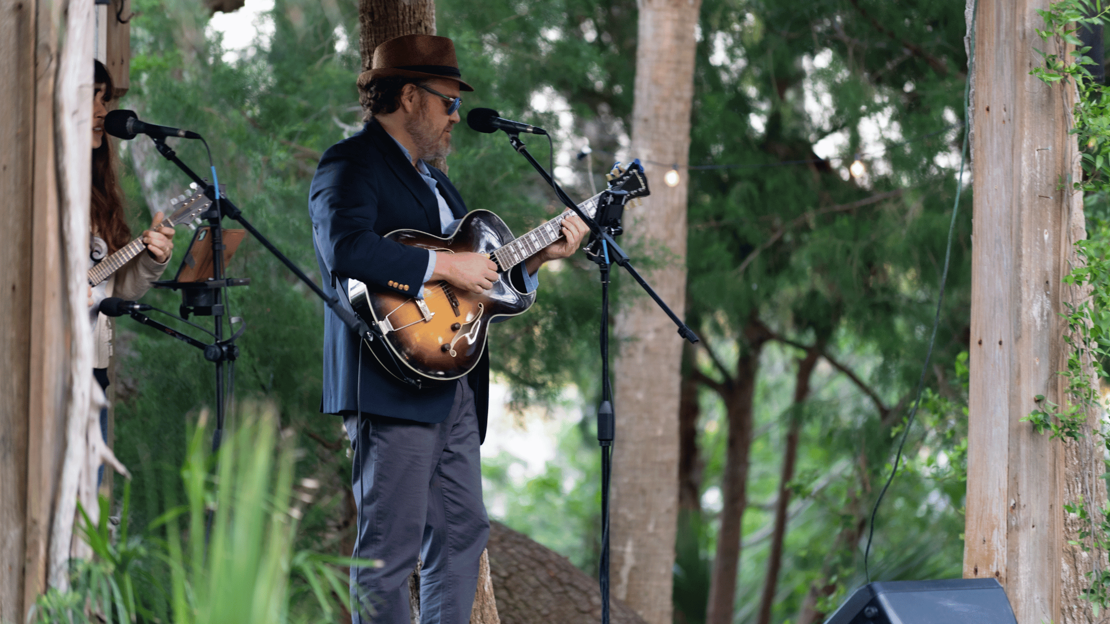 a man playing guitar in front of a microphone