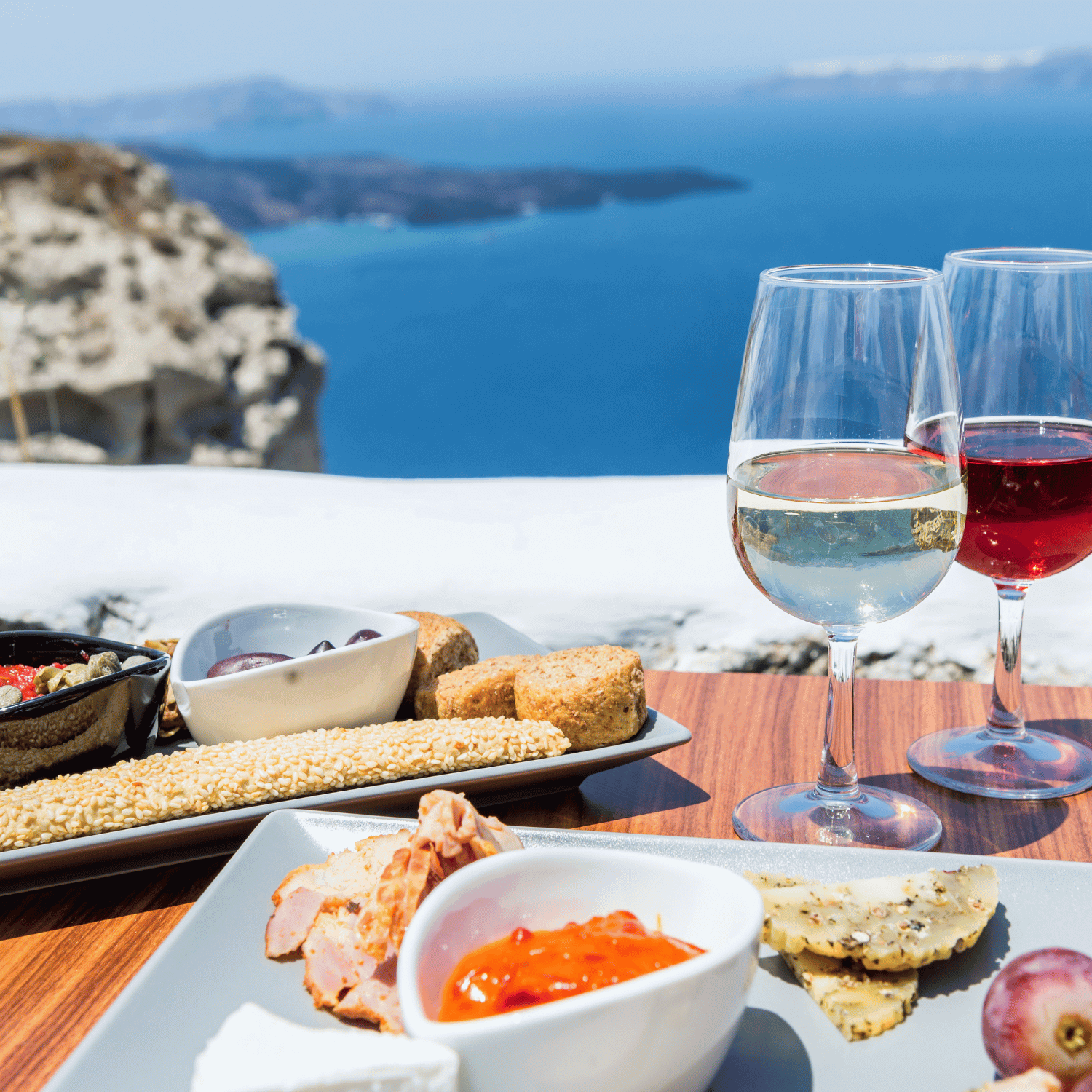 Wine and small bites on a balcony in Santorini Greece overlooking the Sea