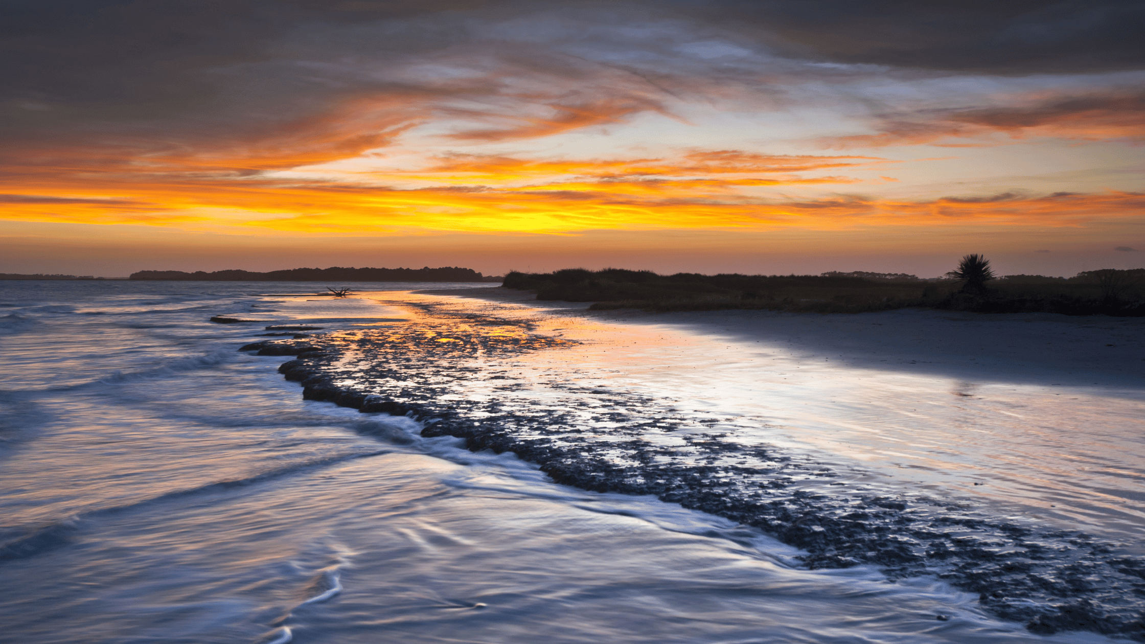 The waves breaking over the beach