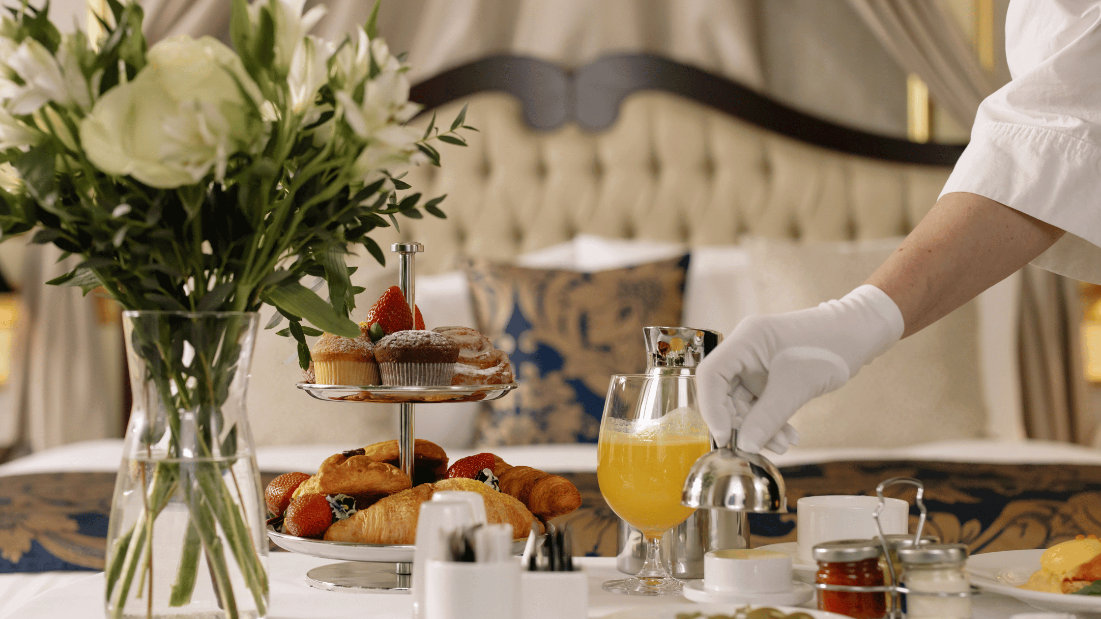 Hotel room service food with flowers near bed