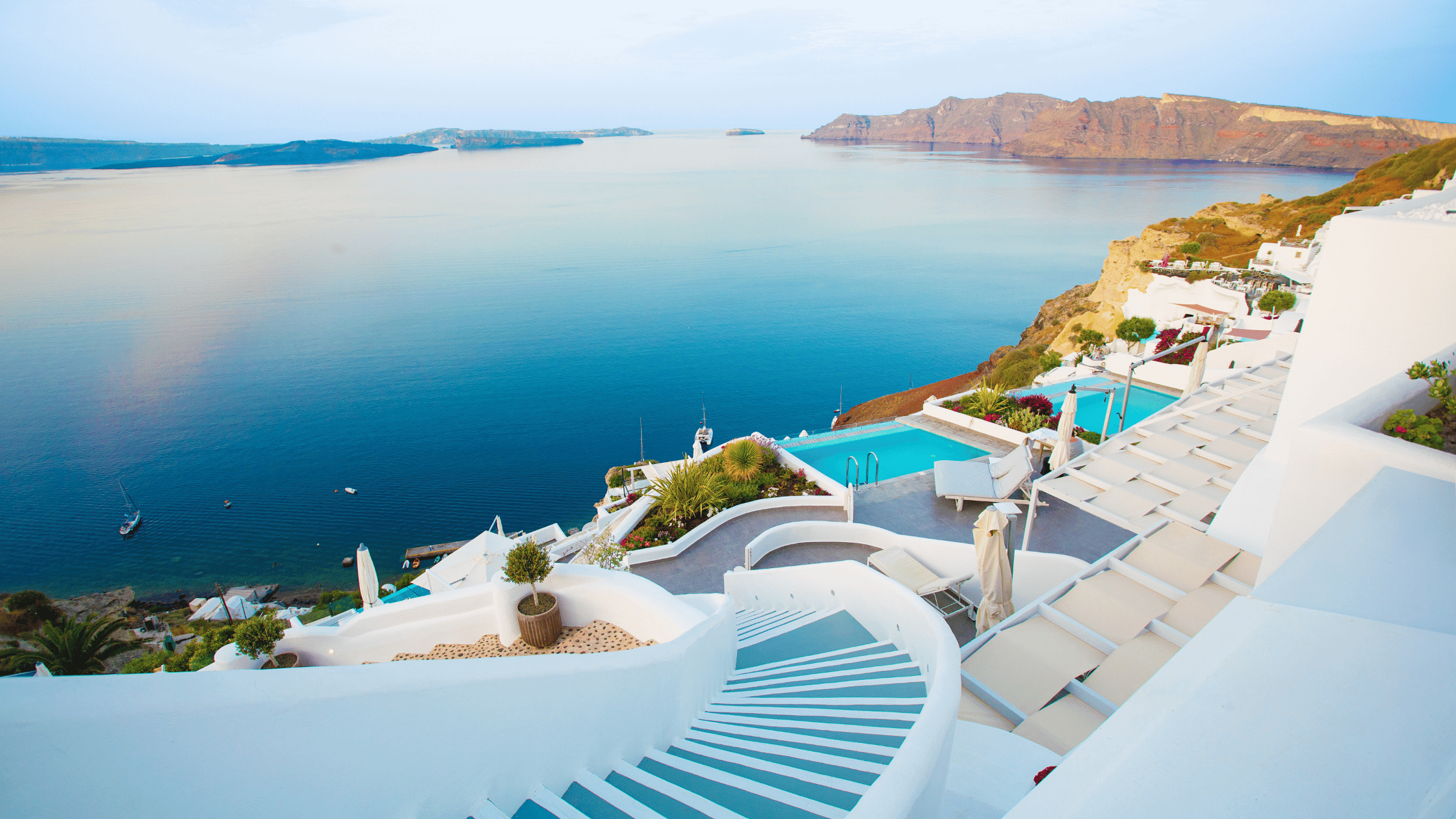 Luxury hotel balcony over looking Aegean Sea and pools 