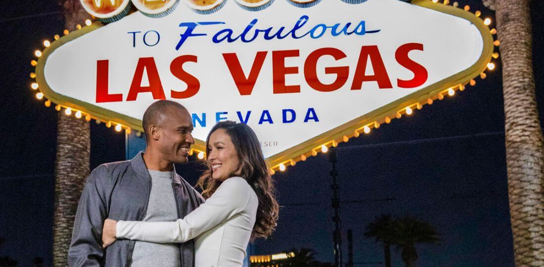 Las Vegas sign with a couple in front of it