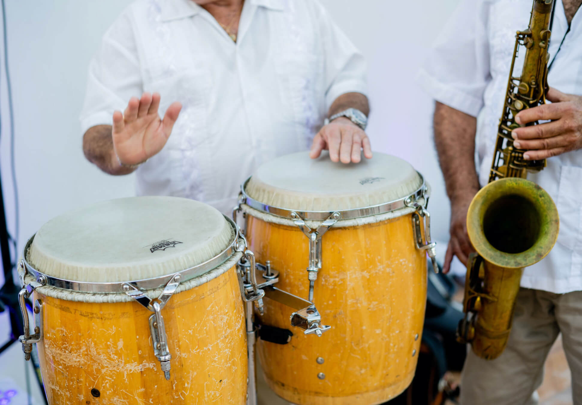 Close up of Bongos and players hands with a saxaphone