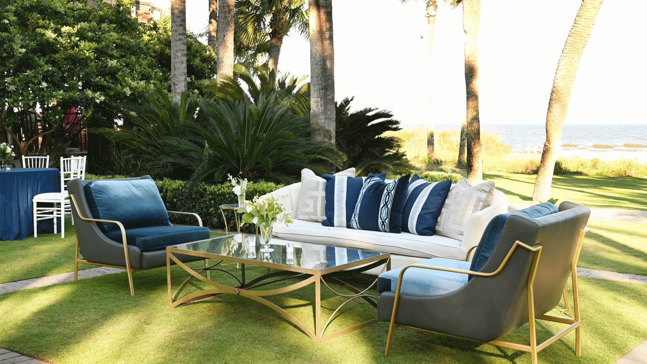 Chic lounge set up on grass with ocean behind it